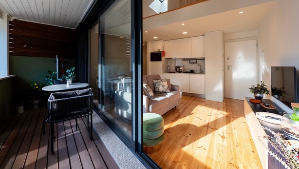 A modern interior with a dining area, a sofa, and a kitchen. - Porto Luxe Stay: Garden & Pool (Porto)