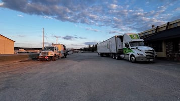 A parking lot with two trucks, one white and one orange, parked near a building with a sign that reads "CoreMark."