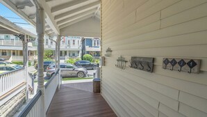 A covered porch with a view of parked cars and neighboring houses. - 20 Grover's Ocean, spacious 5 bedroom home with central AC, 1 block to beach! (Neptune Township)