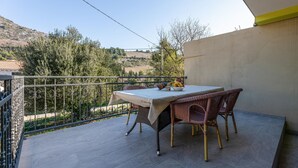 A balcony with a table and chairs, a bowl of fruit, and a view of the countryside. - 3 bedroom cozy home in Kremena (Kremena)