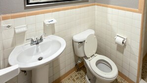 Un baño con lavamanos, inodoro y toallero.