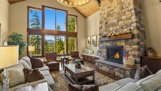 A spacious living room with a stone fireplace, large windows, and a high wooden ceiling. - Sunset Lodge: Luxury, Views & Endless Fun (Cle Elum)