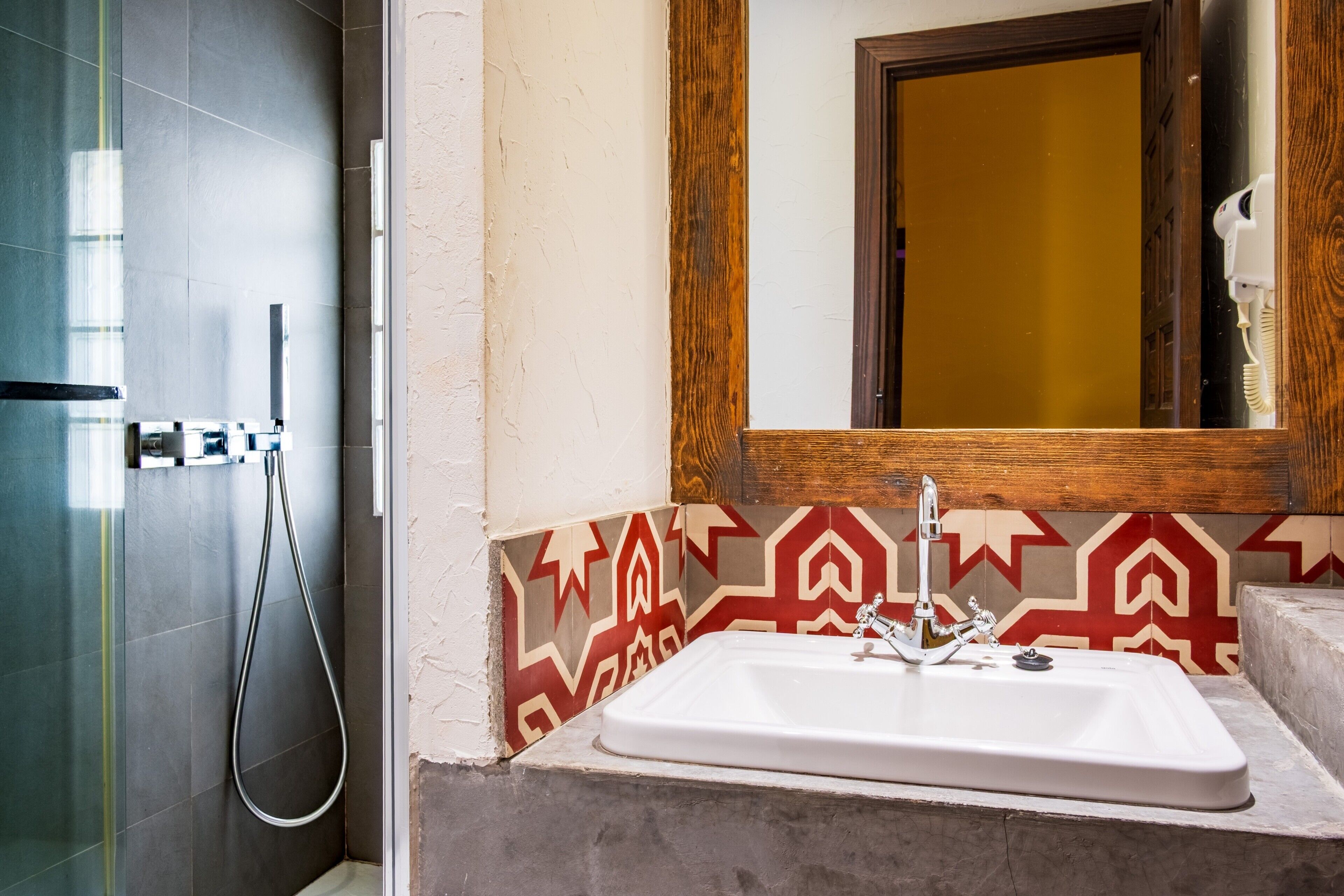 Ein Badezimmer mit Dusche, Waschbecken und Spiegel.