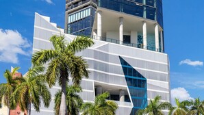 A modern hotel with a prominent glass facade, multiple floors, and a distinctive geometric design.