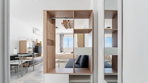 A modern interior with a kitchen, dining area, and a built-in seating area with a view.
