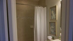A bathroom with a shower, toilet, and sink.