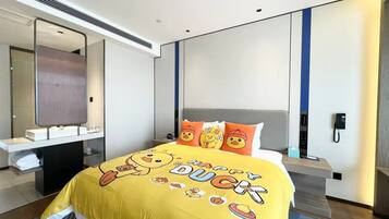 Habitación de hotel con una cama grande, una mesita de noche, un espejo y un baño con lavabo y toallero.
