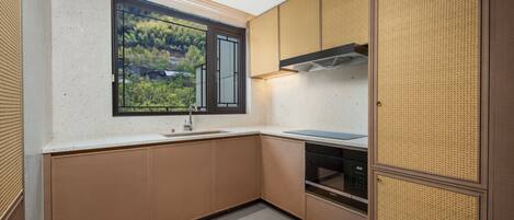 A modern kitchen with a window, built-in oven, and a dishwasher.