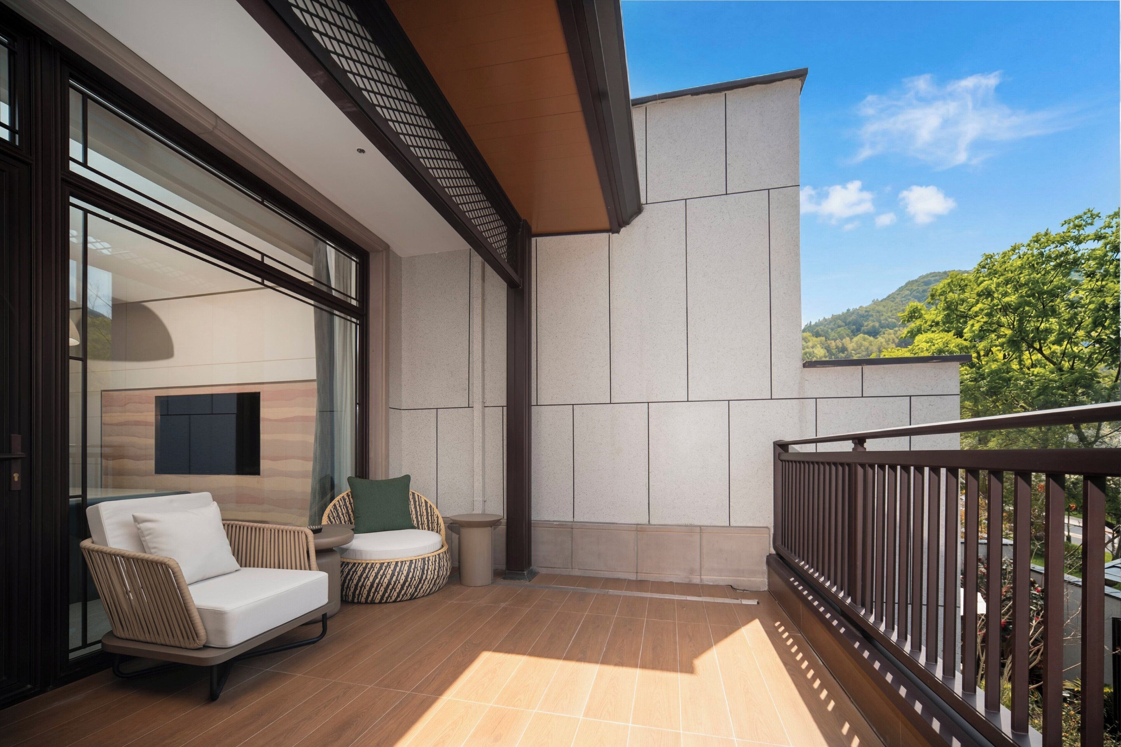 A balcony with a sofa, a small table, and a trash bin.
