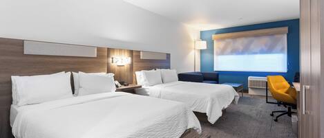 A hotel room with two beds, a desk, a chair, and a large window with blinds.