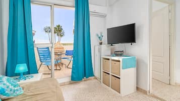 Una habitación con cama, televisión, escritorio y vistas al exterior.