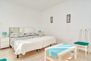 Een slaapkamer met een bed, nachtkastjes, een stoel en een spiegel.