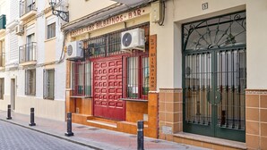 A building with a red door, air conditioning units, and a barred window. - Apartment 'Butterfly' with Private Terrace, Wi-Fi and Air Conditioning (Nerja)
