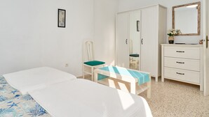 A bedroom with a bed, a chair, a desk, a wardrobe, and a mirror. - Apartment 'Butterfly' with Private Terrace, Wi-Fi and Air Conditioning (Nerja)
