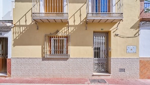 A building with a balcony, a window with bars, and a door. - Apartment 'Naranja' with Private Terrace, Wi-Fi and Air Conditioning (Nerja)