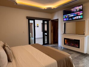A hotel room with a bed, a fireplace, a television, and a door leading outside. - Belova Luxury Hotel, San Cristobal de las Casas (San Cristóbal de las Casas)