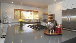 A modern kitchen with a central island, stainless steel appliances, and decorative items.
