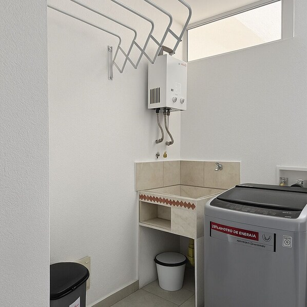 A bathroom with a shower, a toilet, a trash bin, and a water heater. - Beautiful Mountain View in the North of Cali (Cali)