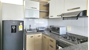 A modern kitchen with a built-in stove, microwave, and coffee maker.