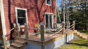 Une terrasse en bois avec des marches menant à une maison à l’extérieur rouge.
