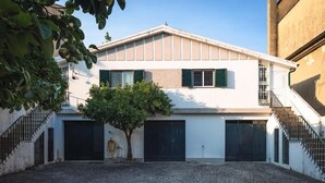 A building with a white facade, green shutters, and a tree in the courtyard. - Holiday Home 'Vez' with Mountain View, Private Garden and Wi-Fi (Arcos de Valdevez)