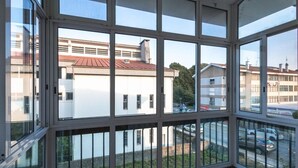 A room with large windows, a view of buildings, and a parking area. - Holiday Home 'Vez' with Mountain View, Private Garden and Wi-Fi (Arcos de Valdevez)