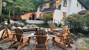 A modern house with a balcony, surrounded by a garden with wooden chairs and a fire pit. - Private Pool 5 Minutes From Lake Michigan (South Haven)