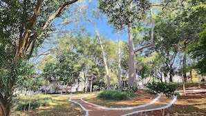 A pathway winding through a garden with trees and shrubs. - Private Room. SP Expo, Itaú, IBC, Congonhas, Zoo (São Paulo)