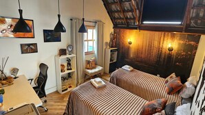 Un dormitorio acogedor con dos camas, un escritorio, una silla y una estantería.