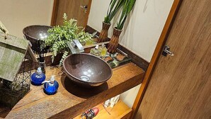Un baño moderno con tocador de madera, un espejo grande y un felpudo decorativo en el suelo.