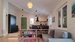 Un salon moderne comprenant un canapé, une table basse, une bibliothèque et un coin repas.