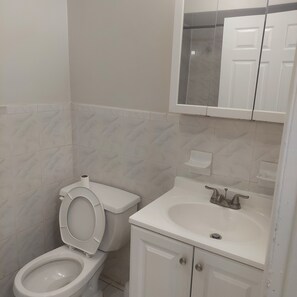 Un baño con inodoro, lavabo y armario.