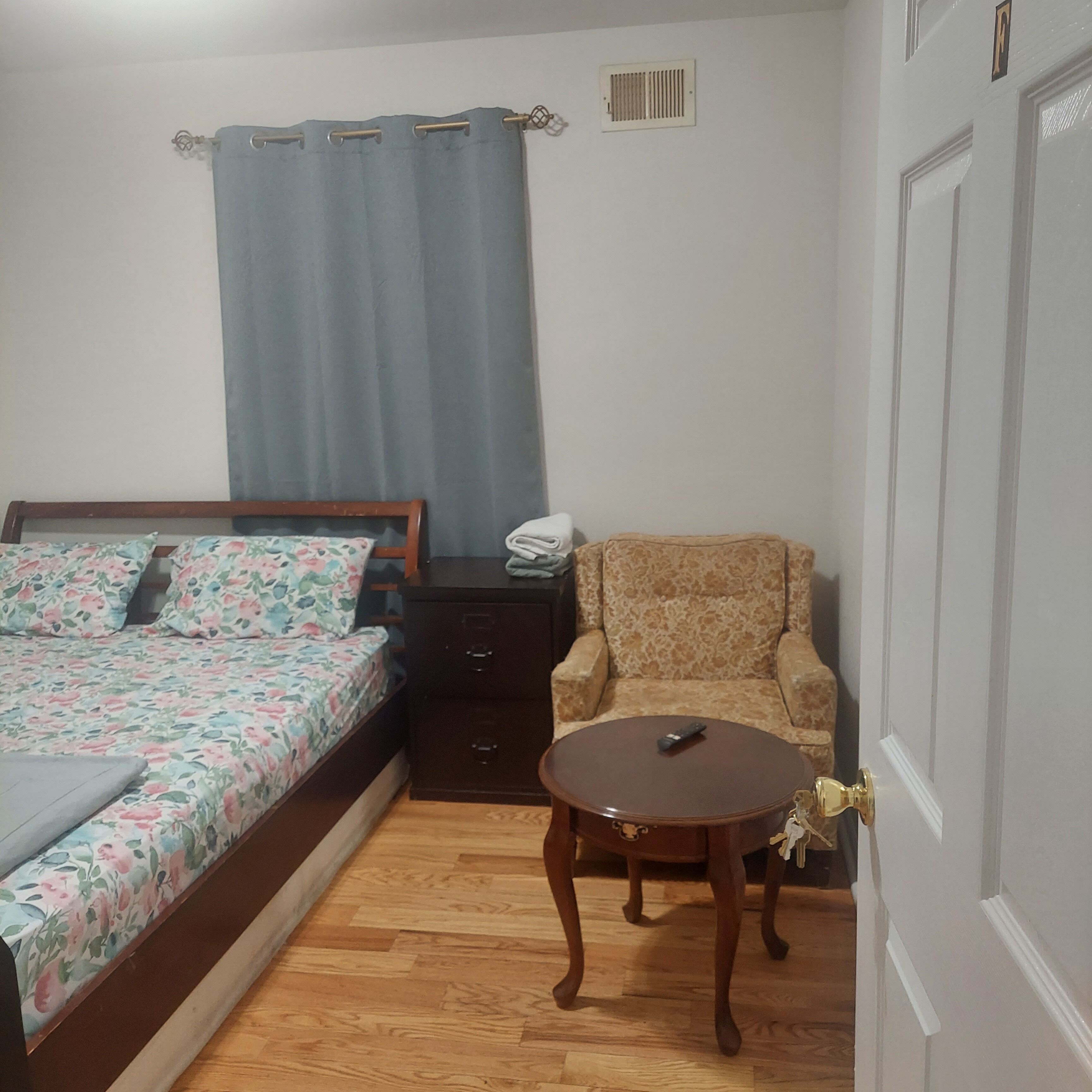 Une chambre à coucher avec un lit, une table de chevet, une chaise et une petite table.