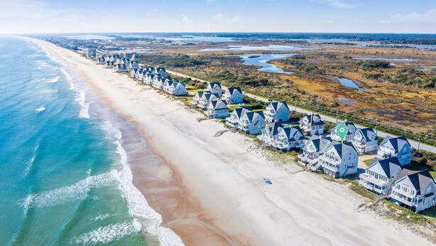 A coastal area with a row of houses along the beach, a sandy shoreline, and a view of the ocean. - Oceanfront Paradise with Amazing Views! (North Topsail Beach)
