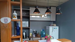Ein Empfangsbereich mit Holztresen, einem Schild mit der Aufschrift Route 66, einem Kühlschrank, einer Mikrowelle und einem Wasserspender.