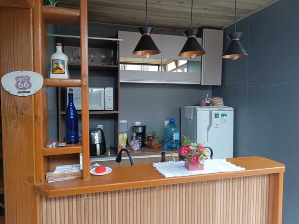 Una zona de recepción con mostrador de madera, un cartel de la Ruta 66, un refrigerador, un microondas y un dispensador de agua.