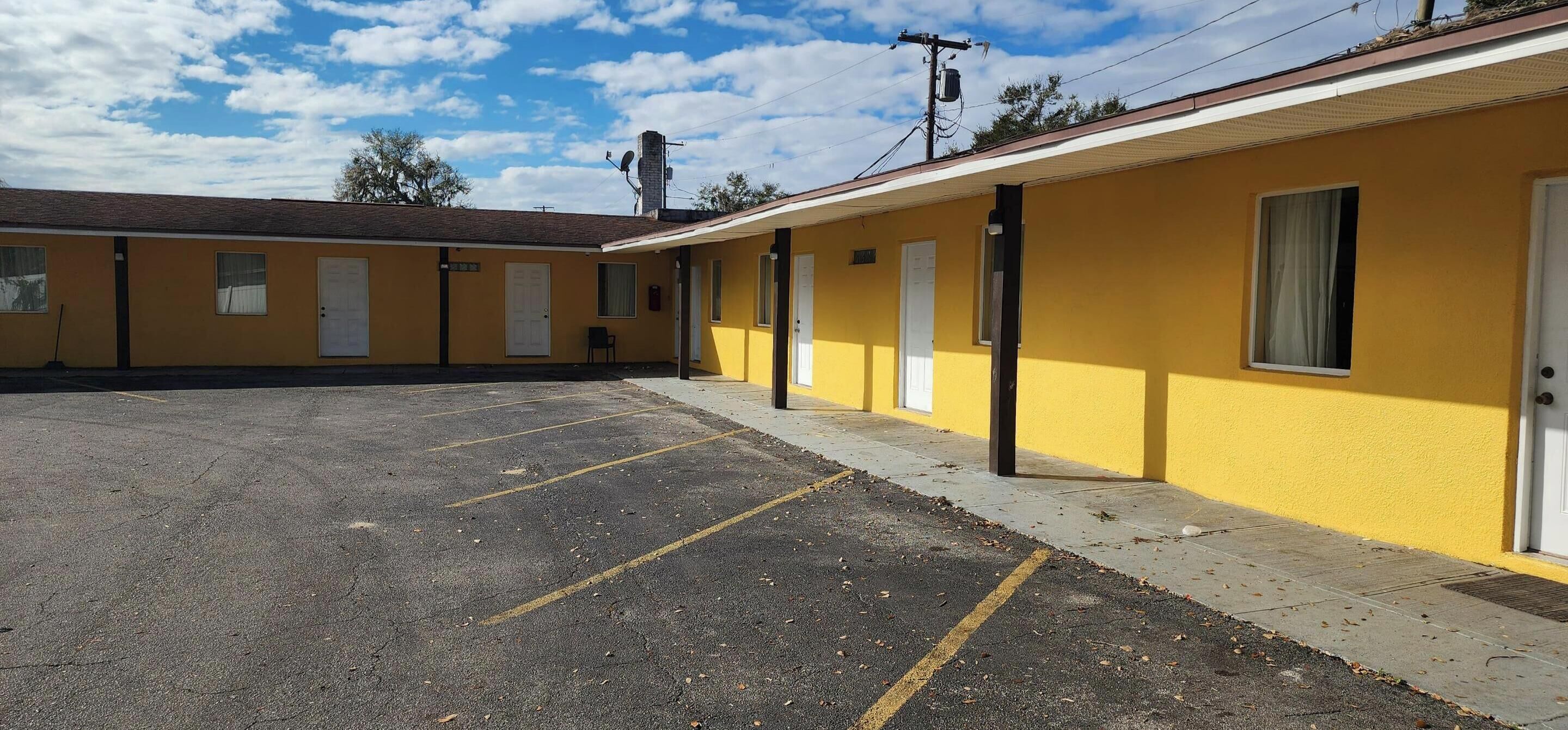 Un motel doté d’un parking, de plusieurs chambres et offrant une vue sur un ciel dégagé.