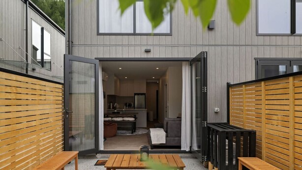 Une maison moderne dotée d’un espace de vie à aire ouverte, d’une cuisine et d’un coin repas.