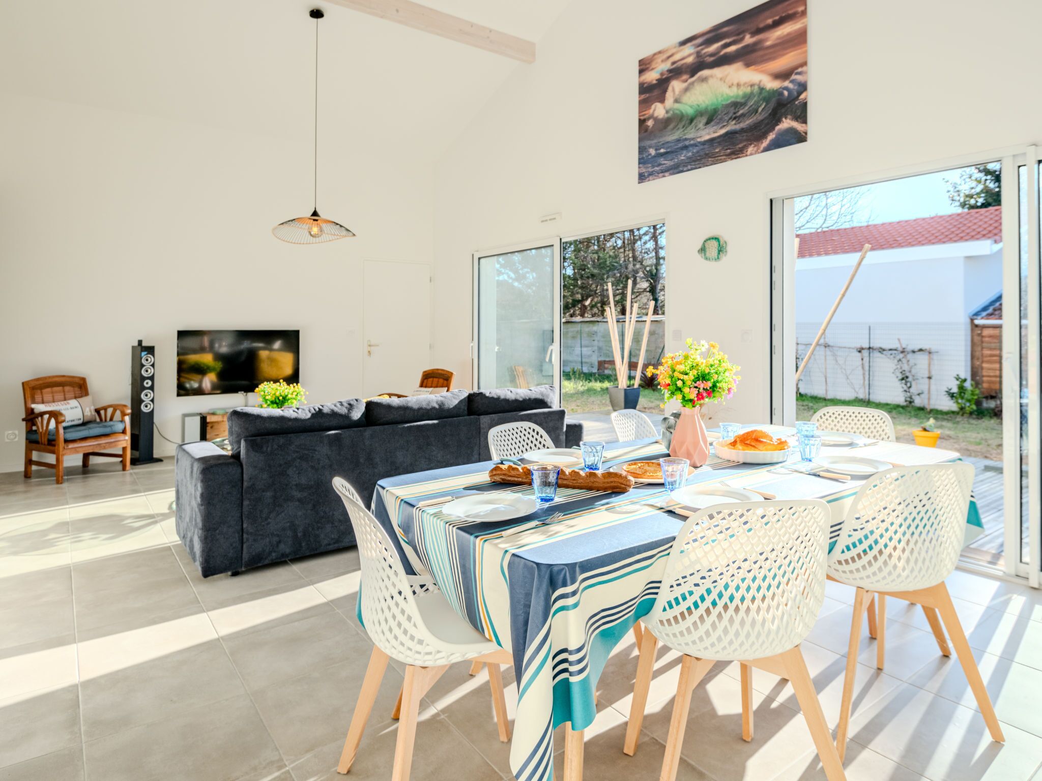 Ein modernes Wohnzimmer mit einer Couch, einem Esstisch, Stühlen und einem Fernseher.