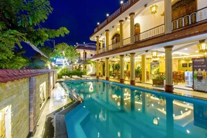 A pool area with a covered seating area, a dining section, and a Coca-Cola sign. - Ancient HoiAn Hotel (Da Nang)