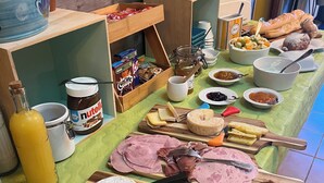 Un bufé de desayuno con varios quesos, embutidos y untables.
