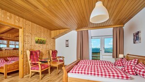 A wooden room with a bed, two chairs, a table, and a window with a view. - Marianne by Interhome (Sankt Englmar)