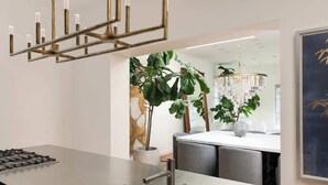 A modern kitchen with a stainless steel sink, a gas stove, and a pendant light.