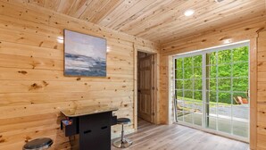 A wooden-paneled room with a bar area, a large window, and a door leading outside. - "Ultimate Luxe Escape with Private Movie Theater and Game Room" (Nelsonville)