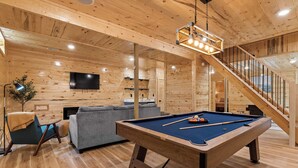 A wooden interior with a pool table, sofa, and staircase. - "Ultimate Luxe Escape with Private Movie Theater and Game Room" (Nelsonville)