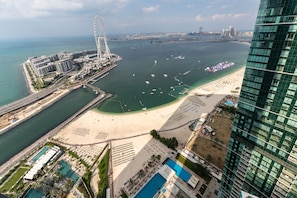 Un complejo turístico costero con playa, una gran masa de agua y un edificio moderno.