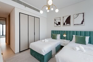 Una habitación de hotel moderna con dos camas, un armario y obras de arte en la pared.