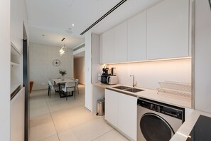 Una cocina funcional con lavadora, microondas y lavamanos.