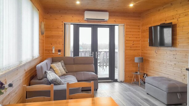 En inredning med träpanel, en soffa, ett bord och en tv.