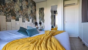 A bedroom with a large bed, a decorative wall, a wardrobe, and a door.